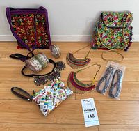 All items laid out including 2 embroidered bags, wristlet, necklaces, eyeglass tethers, bangles, packaged bracelets