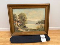 Full view of framed landscape painting on stand