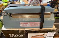 Left side view of impulse sealer on its box