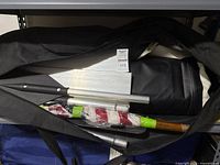 Bag opened showing dinghy, paddles, wrapped flag and poles