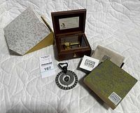 Music box open showing mechanism, ornament, boxes, pouch