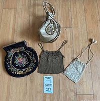 Four assorted vintage evening bags displayed on floor