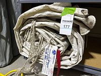 Rolled mainsail on shelf with tag