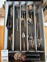 drawer view showing mixed flatware, steak knives, can opener