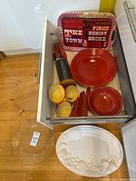 Drawer view showing red trays, plates, bowls, multicolour bowls, knife block