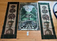 Full view of three tapestries laid out on floor