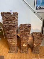 All three wicker floor lamps lit, showing relative sizes