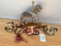 Group shot showing three masks, Murano glass piece, carousel horse figurine