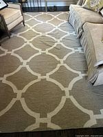 Full view of taupe rug with ivory lattice pattern between sofa and chairs