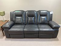 Front view of three-seat charcoal leather reclining couch
