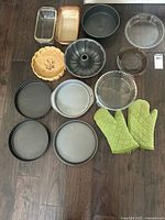 Overview of entire lot showing all bakeware pieces and oven mitts