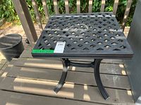 Top view of black metal square outdoor side table on deck