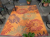 Full view of rectangular outdoor rug on deck showing entire floral pattern