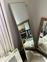 Front view of full-length gold-framed mirror standing on easel