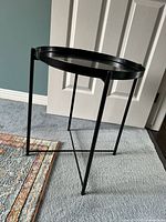 Full view of black metal side table showing frame and tray top