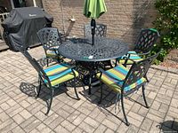 full set showing table, five chairs, cushions and umbrella