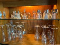 Overall view of shelves with stemware, tumblers, gravy boat, butter dish, shakers