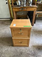 Front view showing two drawers, metal pulls, key in lock