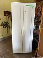 Full front view of closed white double-door wardrobe