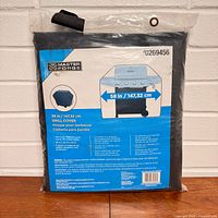 Front of sealed Master Forge grill cover package showing brand and size
