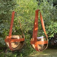 Two matching metal bowl planters hanging outdoors