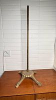 Full view of brass stand showing pole and tripod base