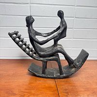 Front view of abstract mother and child metal sculpture on rocking chair