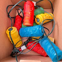 Boxed view of multicolour plastic tiki head light covers with attached wiring