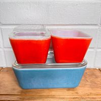 Stacked view of two red 501 dishes on blue 502 dish with lids