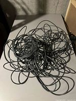 Tangled black Ethernet cable placed on a flat surface.