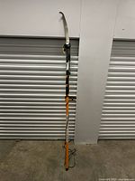 Full view of Fiskars long reach pole saw trimmer with handle and curved blade.