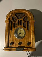 Front view of vintage Thomas radio showing wooden cabinet with grille, circular dial, three knobs, and brand plaque