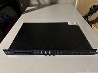 Front view of XTA DP446 Audio Management System showing the LCD screen and control buttons.