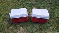 Two red and white Rubbermaid chest coolers closed