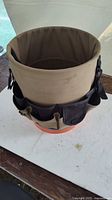 Side view of bucket with khaki canvas organizer belt