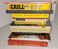 Stack of nine cookbooks showing titles on spines