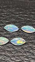 Four polished marquis cut Ethiopian opals displayed on a black textured background showcasing their multi-color flash.