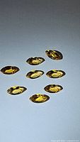 Eight marquis cut natural golden citrine gemstones with strong brilliance and golden-yellow color, displayed on a white background