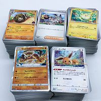 Five stacked, rubber-banded bundles of Japanese Pokémon cards showing mix of artworks and holofoil cards