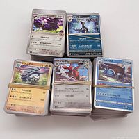 Five bundles of rubber-banded Japanese Pokémon cards