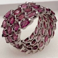 Angled close-up of ring showing marquise rhodolite garnets and silver setting interior