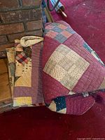 Both folded quilts beside brick wall