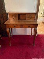 Front view of antique wood writing desk showing hutch drawers and lower drawers