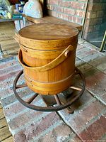 Front view of barrel churn on wheel base showing handle, bands, and spoke wheel