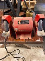 Front view of Ashland bench grinder showing wheels, housing, cord