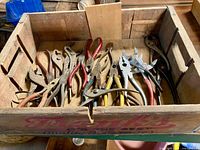 Wide view of crate filled with assorted pliers