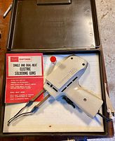 Open case showing soldering gun, instruction sheet and tube of solder