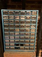 Front view of cabinet showing 60 drawers filled with hardware