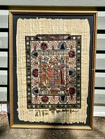 Full framed papyrus artwork against wall