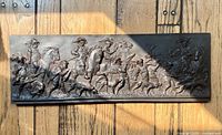 Full view of metal plaque showing entire hunting scene relief